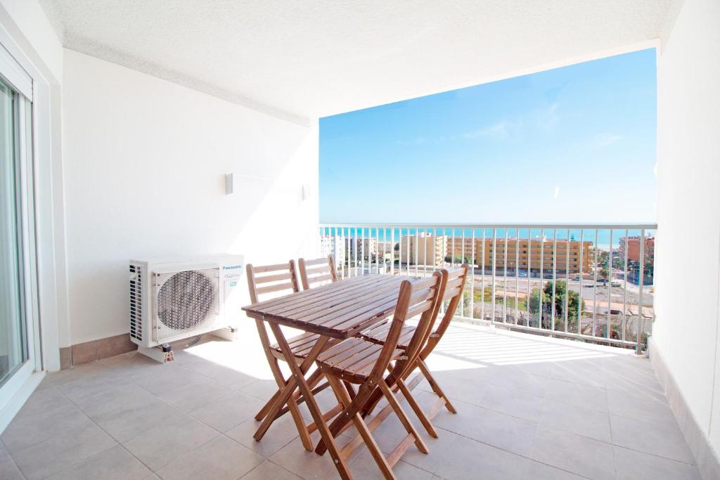 comedor con mesa y sillas en el balcón en Global Properties, Increible apartamento con vistas al mar, Canet d'en Berenguer, en Canet de Berenguer