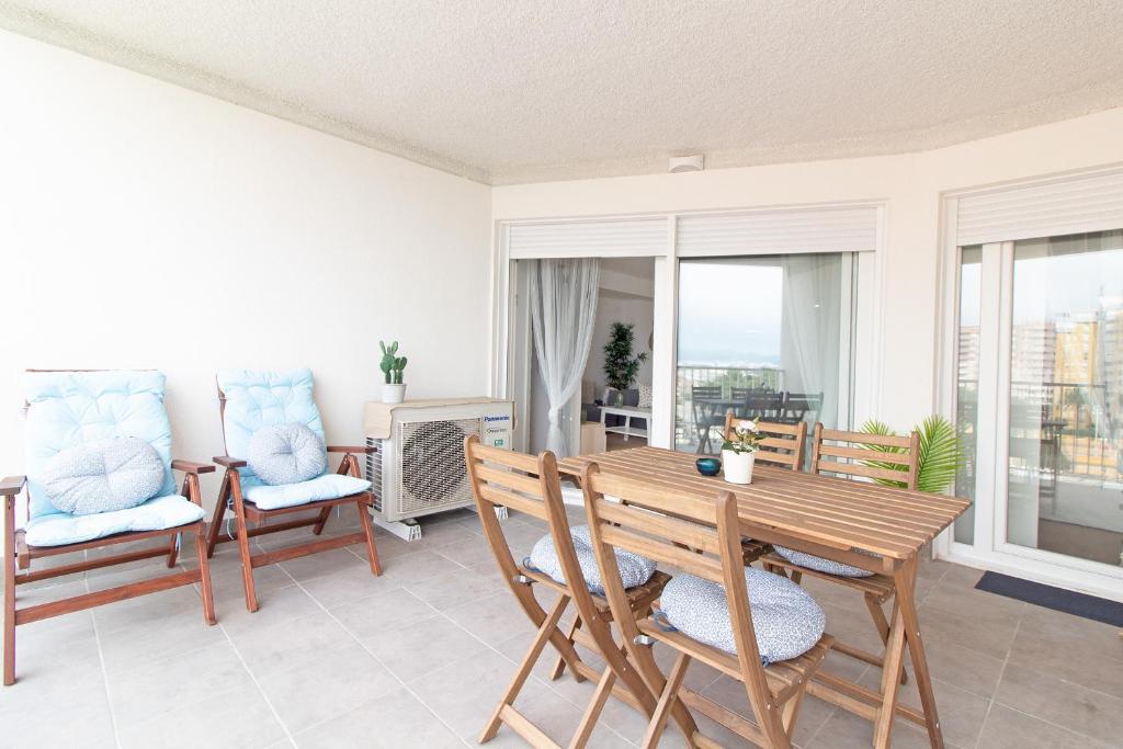 sala de estar con mesa de madera y sillas en Global Properties, Apartamento nuevo en la playa de Canet d'en Berenguer, en Canet de Berenguer