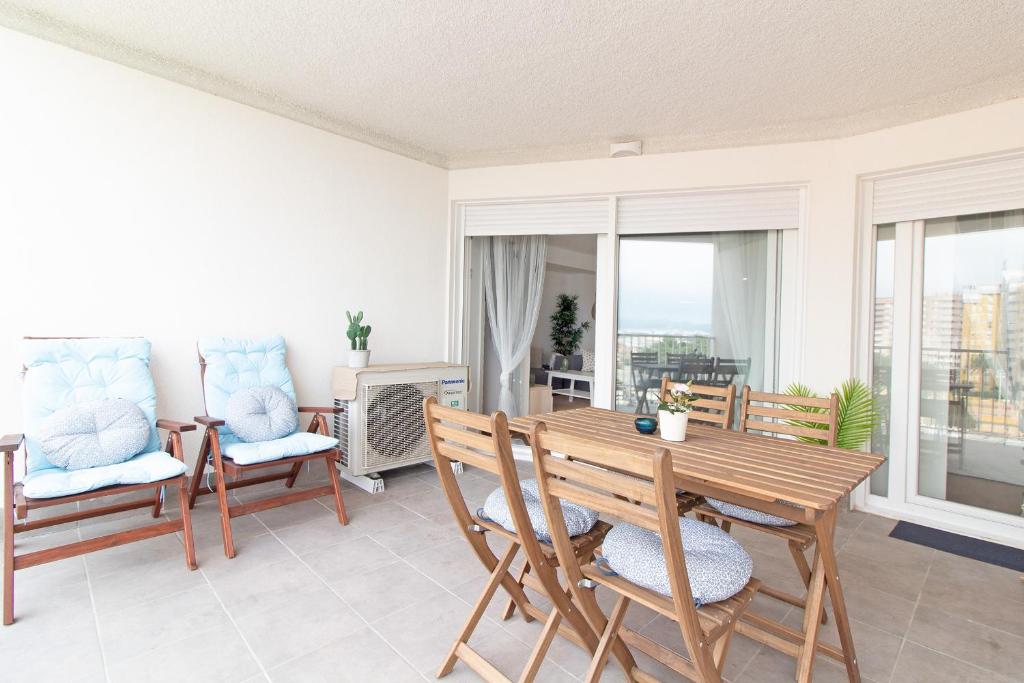 ein Wohnzimmer mit einem Holztisch und Stühlen in der Unterkunft Global Properties, Apartamento nuevo en la playa de Canet d'en Berenguer in Canet d'en Berenguer