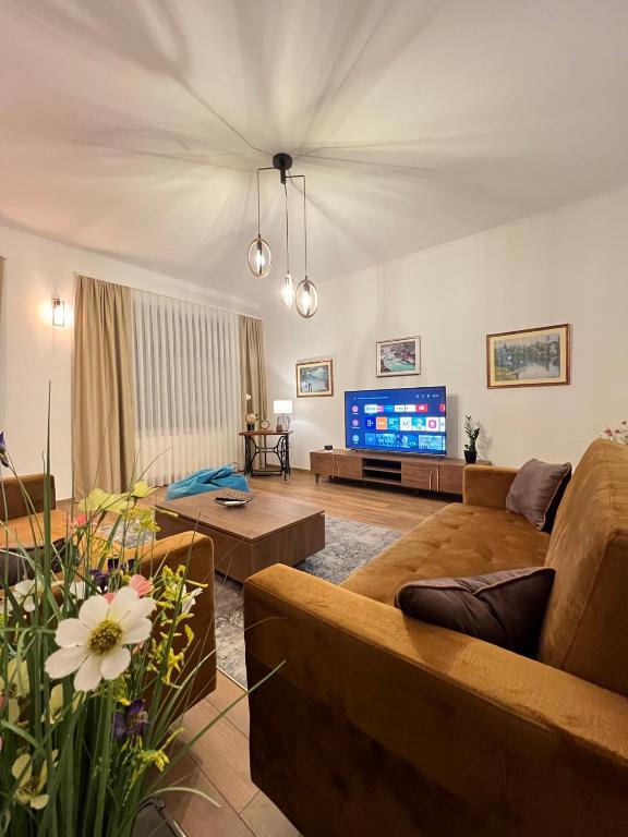 a living room with a couch and a tv at Penthouse City Center in Bihać