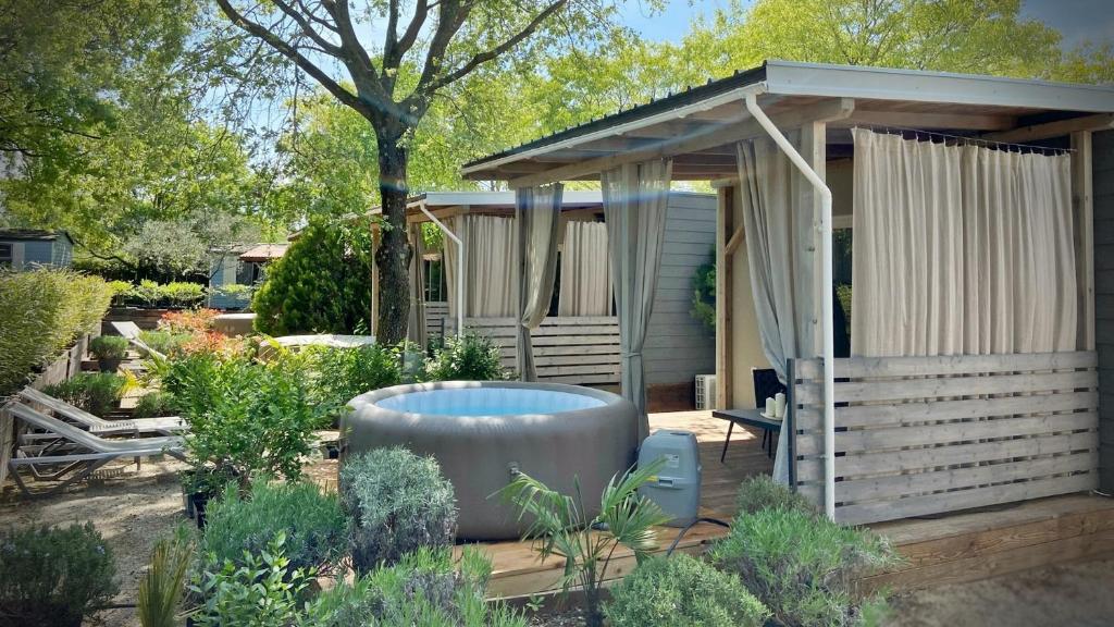 einen Garten mit einem Pavillon und einer Badewanne im Hof in der Unterkunft Boutique Mobile Homes UlikaRovinj in Rovinj