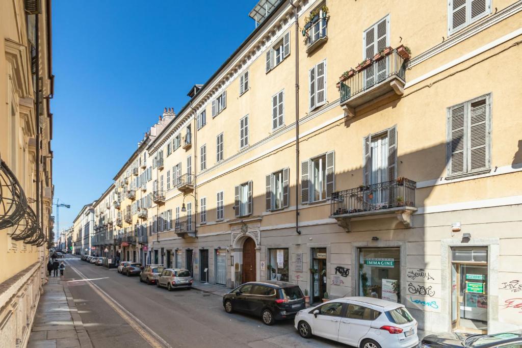 ulica miejska z samochodami zaparkowanymi przed budynkami w obiekcie Loft Alma Rosa vicino a Piazza Vittorio w Turynie