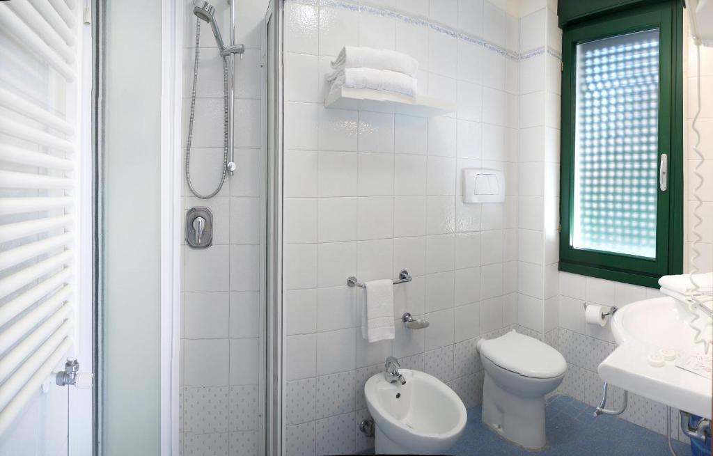 bagno bianco con servizi igienici e lavandino di Hotel Panorama a Lido di Jesolo