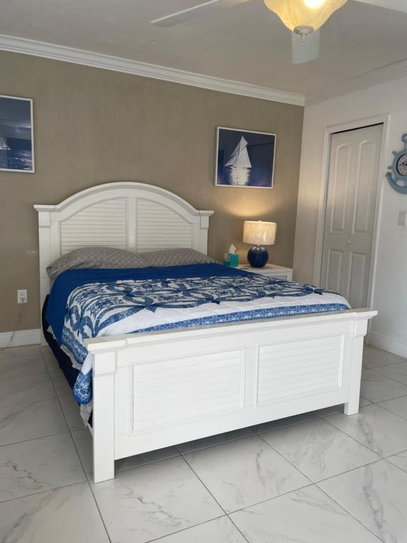 a bedroom with a white bed with a blue comforter at Blue Sky in Fort Myers