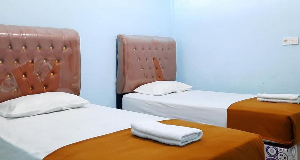 2 posti letto in camera con asciugamani di Prima Homestay Mentawai Mitra RedDoorz a Tua Pejat