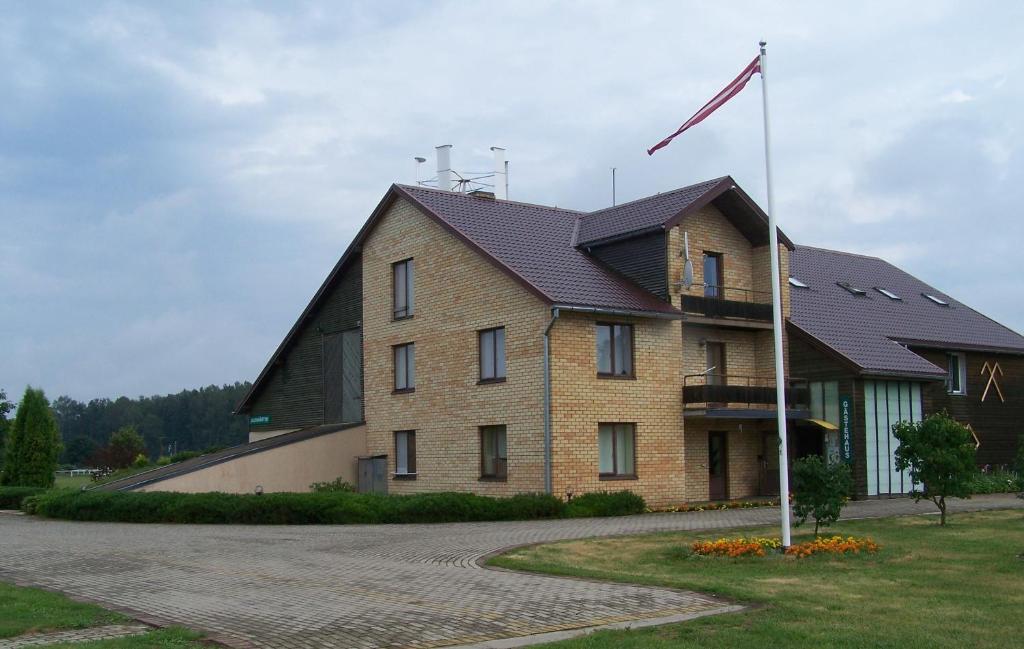 a large brick building with a gambrel roof at Jaunmārtiņi in Jaunmārupe