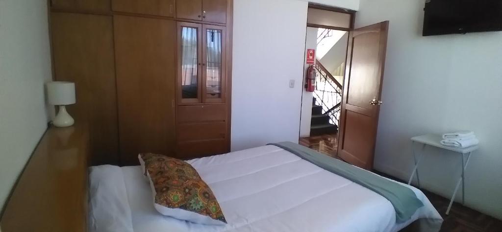 a bedroom with a white bed with a pillow on it at Samadri in Arequipa