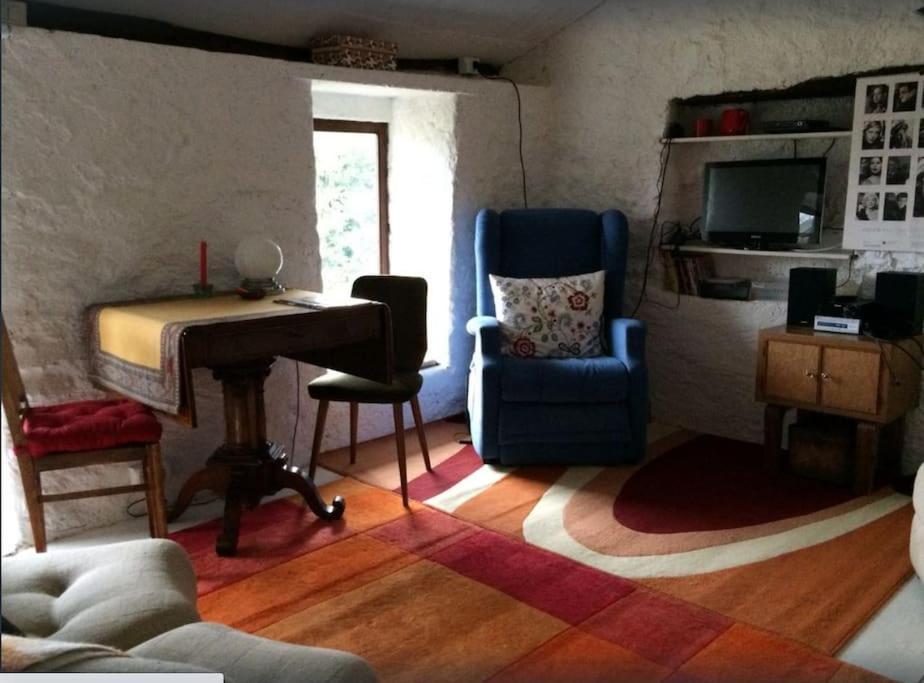 a living room with a piano and a chair and a desk at Country house in Caravate