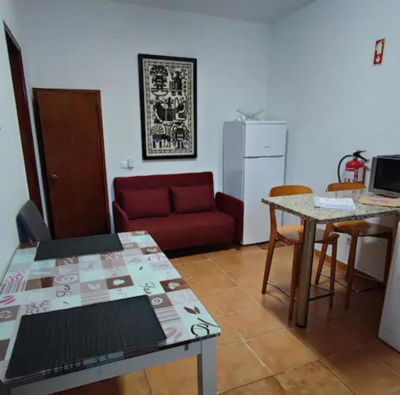 ラゴスにあるCozy Apartment in Lagosのリビングルーム(赤いソファ、テーブル付)