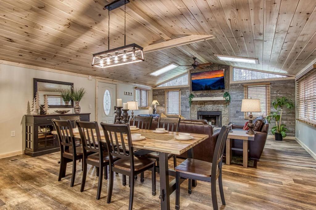 a dining room with a wooden ceiling and a table and chairs at Whispering Winds in Gatlinburg