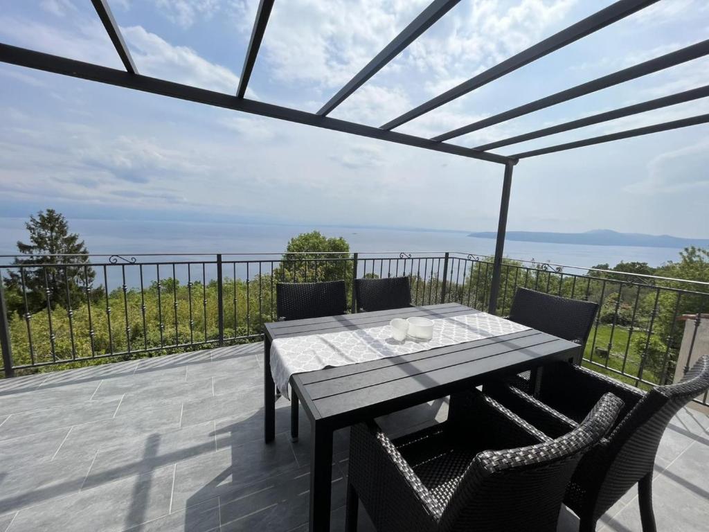 stół i krzesła na patio z widokiem na ocean w obiekcie Holiday Home Anamaria w mieście Mošćenička Draga