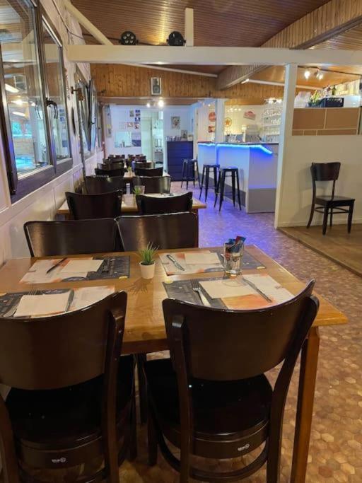 un restaurant avec une grande table et des chaises en bois dans l'établissement Anne Marie vous accueilles dans son logement familiale pour 6 personnes 3 chambres confortable proche d Europa Park a BOOFZHEIM dans CAMPING 3 Etoiles, à Boofzheim