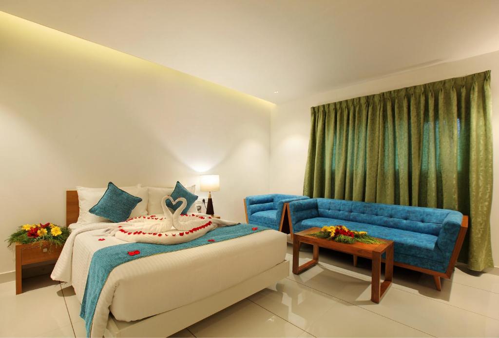 a hotel room with a bed and a blue couch at Harivaram Yuga in Guruvāyūr