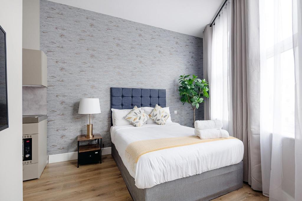 倫敦的住宿－Modern Studio Apartments，一间卧室设有一张大床和砖墙