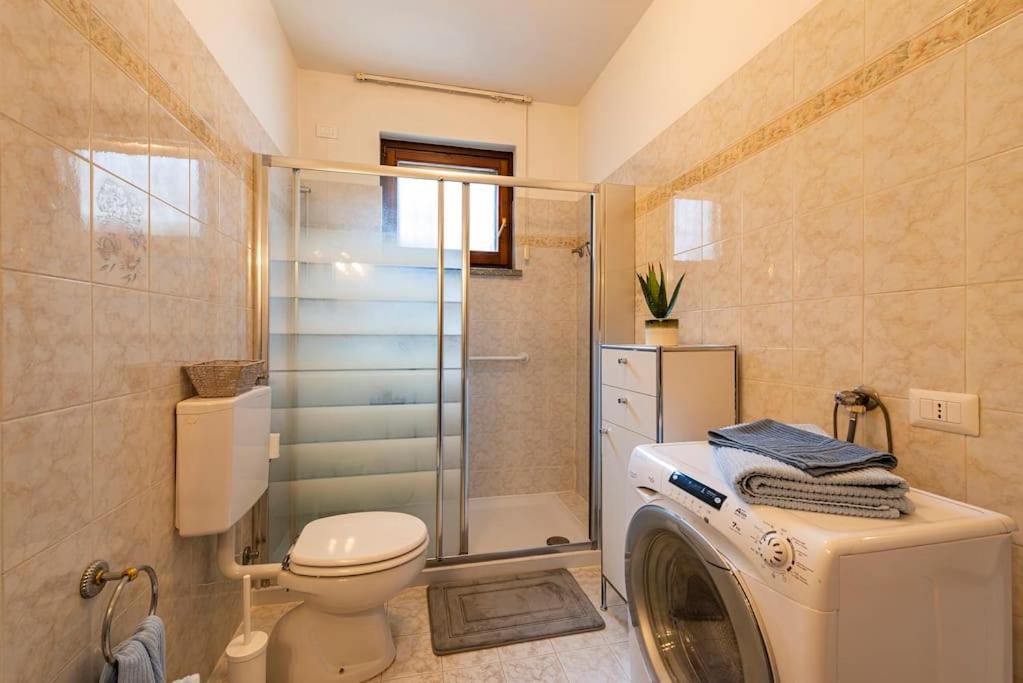 łazienka z toaletą i pralką w obiekcie Tresa Bay House - Lugano Lake w mieście Lavena Ponte Tresa