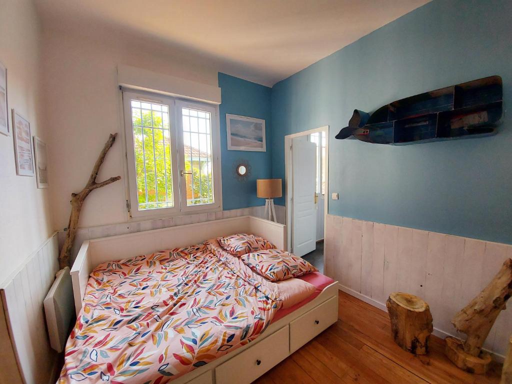 - une chambre avec un lit avec un poisson sur le mur dans l'établissement Appartement 4 pers au coeur de Soulac-sur-mer, à Soulac-sur-Mer