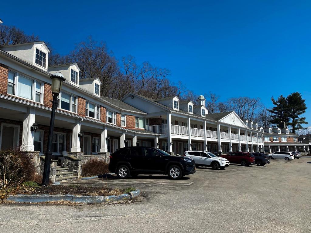 eine Reihe von Häusern mit Autos auf einem Parkplatz in der Unterkunft Inn on the Hudson in Peekskill