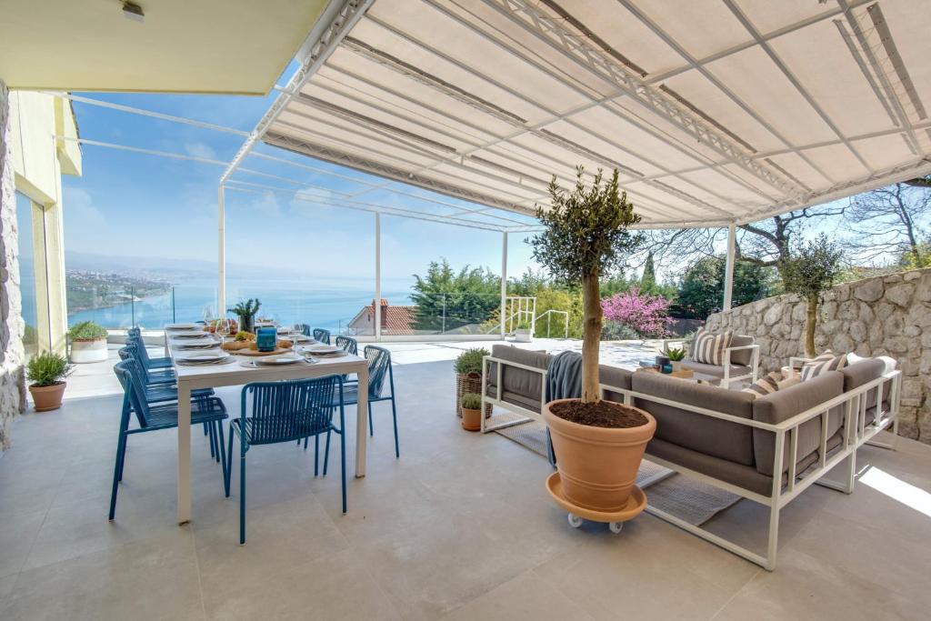 comedor con mesa y sillas con vistas en Premium villa, heatable infinity pool, jacuzzi and seaview, beach and city just 10min by foot, en Volosko