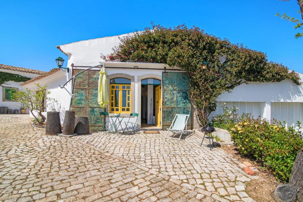 Weißes Haus mit gelber Tür und Terrasse in der Unterkunft Algarve Charming Rural 1br Villa in Santa Bárbara de Nexe