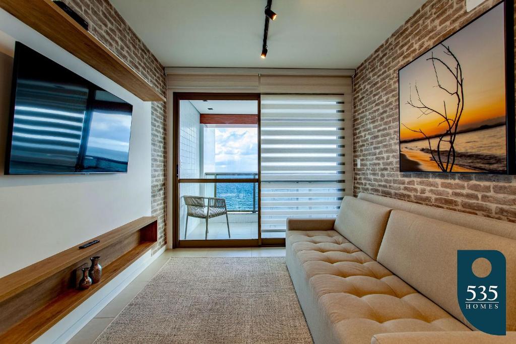 サルバドールにあるBARRA Vista Mar Lindo apartamento, Wi-Fi 300Mbpsのリビングルーム(ソファ、大きな窓付)