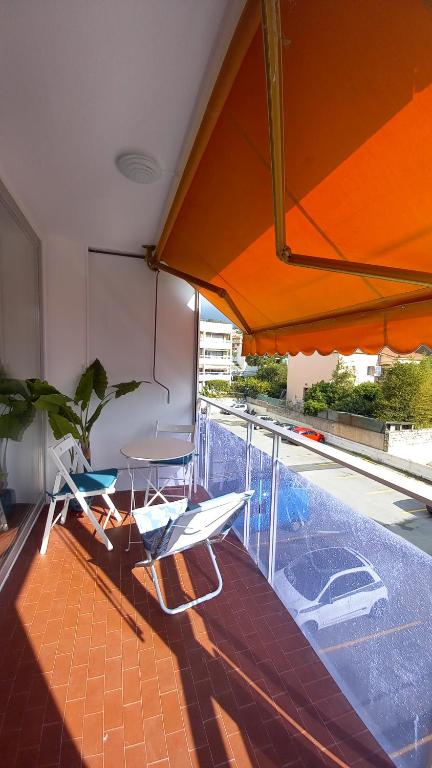 einen Balkon mit einem Tisch, Stühlen und einem Sonnenschirm in der Unterkunft Résidence Le Bonaparte in Roquebrune-Cap-Martin