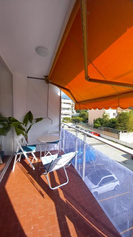 a balcony with a table and chairs and an umbrella at Résidence Le Bonaparte in Roquebrune-Cap-Martin