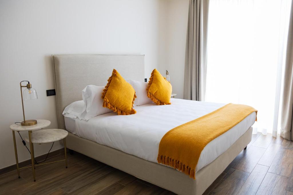 a bedroom with a large bed with yellow pillows at Casabianca Resort in Fondi