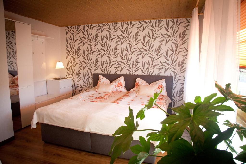 a bedroom with a bed with white sheets and pink pillows at Gästezimmer im Grünen Haus in Thum