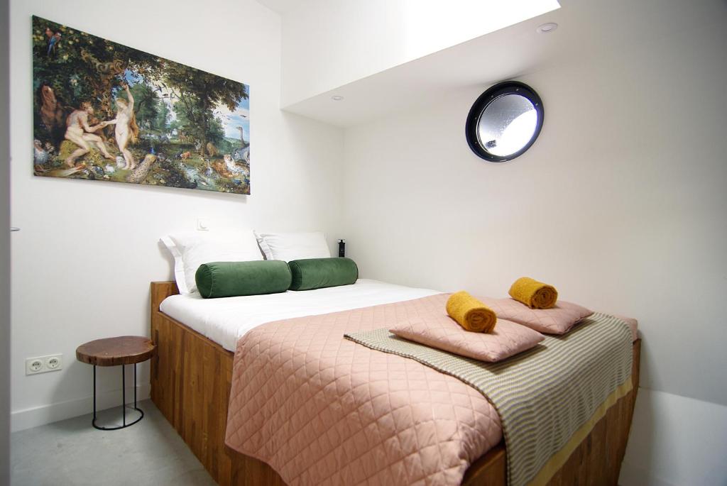 Un dormitorio con una cama con un cuadro en la pared. en Magnificent houseboat with a stunning view!, en Ámsterdam