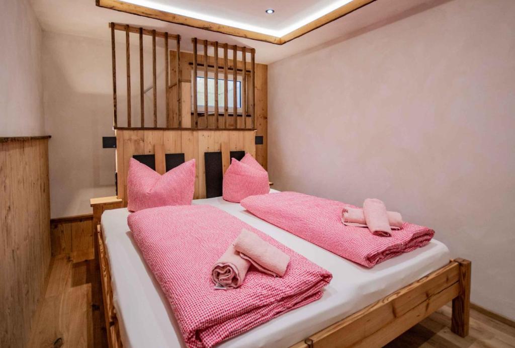 Schlafzimmer mit rosa Handtüchern auf dem Bett in der Unterkunft Peerfect Ferienwohnungen in Navis
