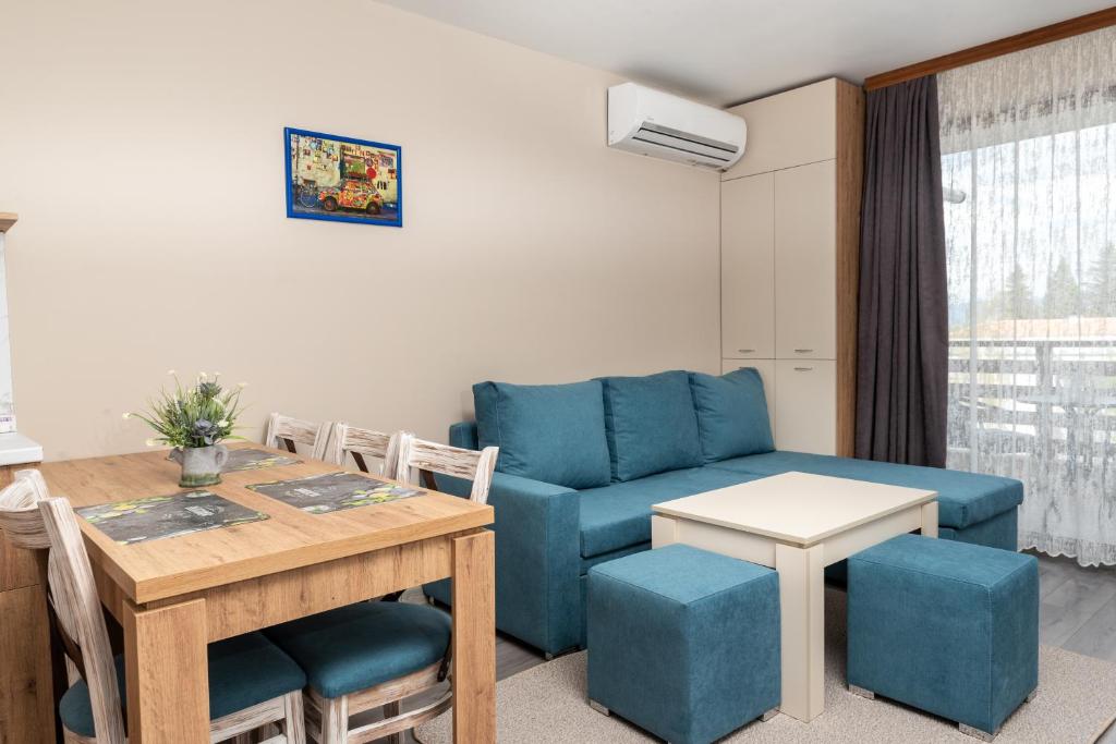 een woonkamer met een blauwe bank en een tafel bij City Apartments 2 in Velingrad