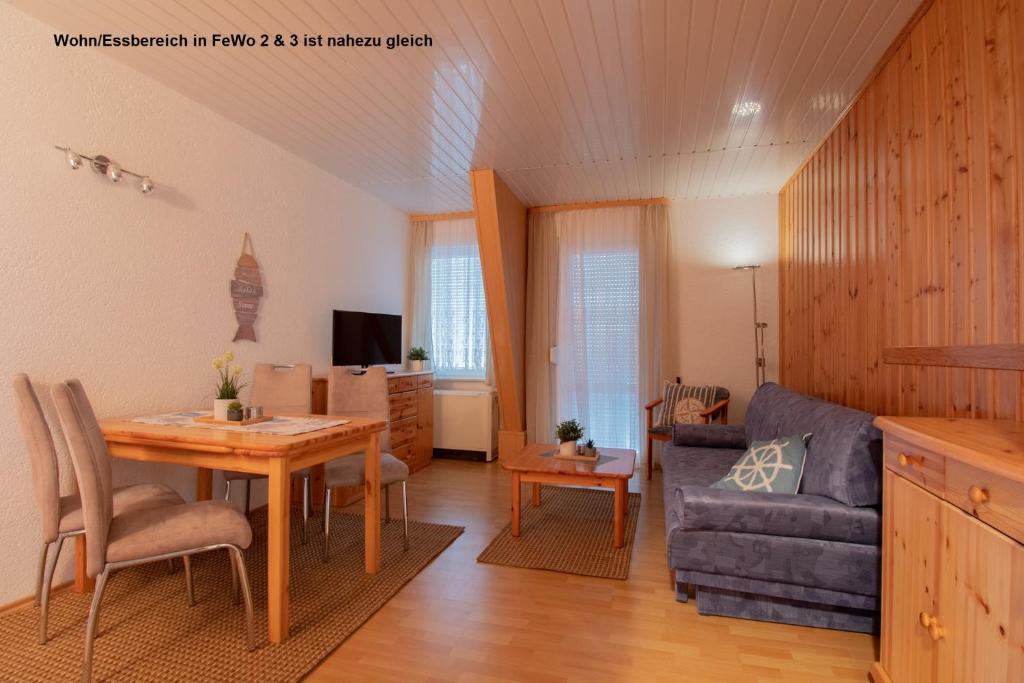 a living room with a table and a couch at Dünenhaus Fewos - Zum Strand 50m in Ueckeritz