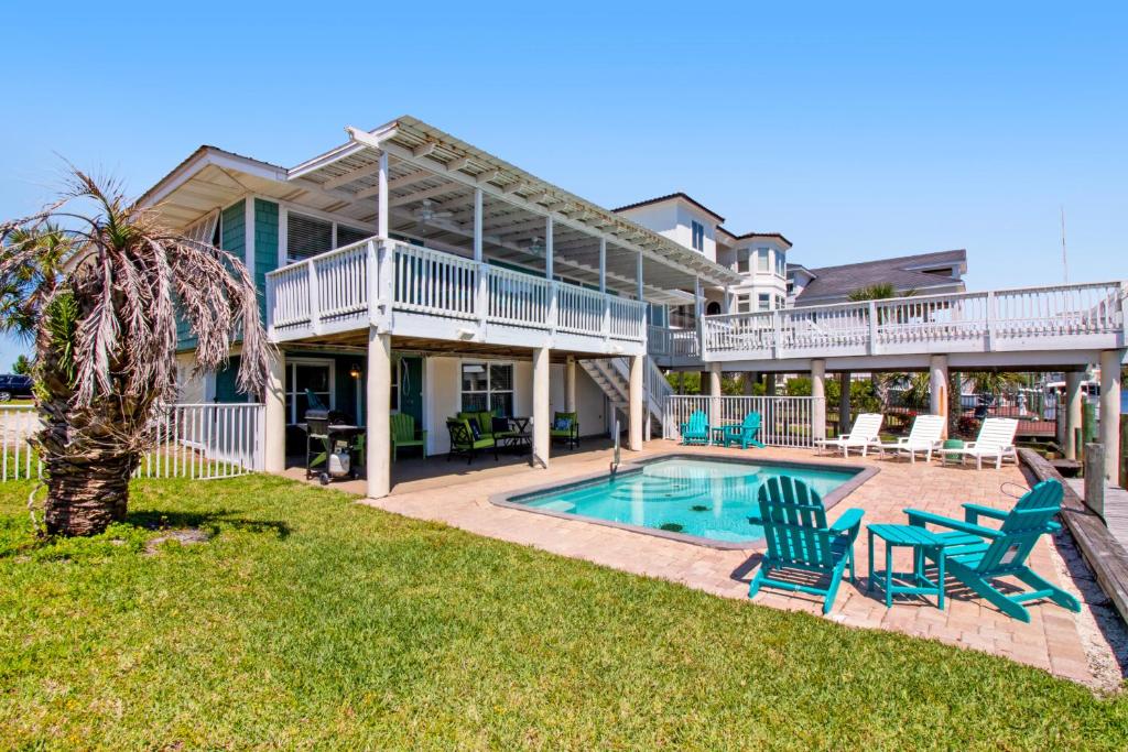 a house with a pool and two lawn chairs at New Kids On The Dock in Destin
