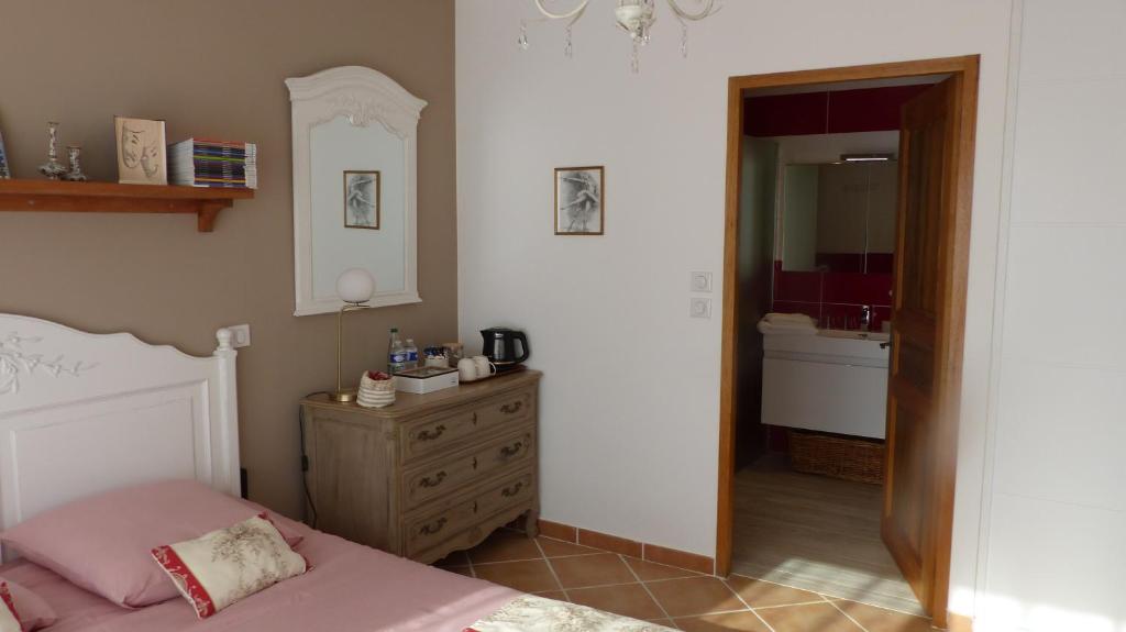 een slaapkamer met een bed, een dressoir en een spiegel bij LE CABANON in Crillon-le-Brave