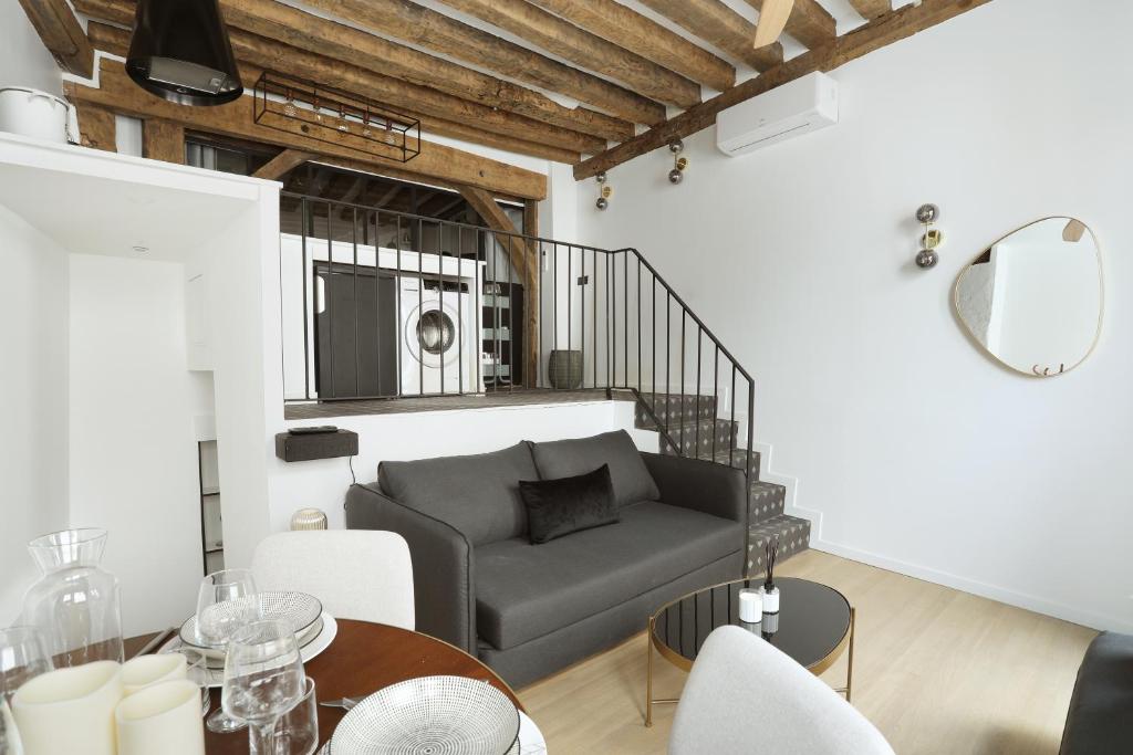 uma sala de estar com um sofá e uma mesa em Apartment Saint Germain des Prés by Studio prestige em Paris