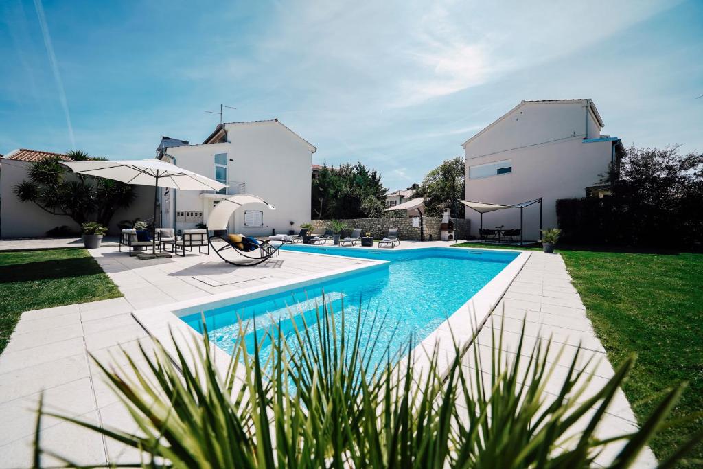 a swimming pool in the backyard of a house at Holiday Home Apartments Bellamare in Zadar