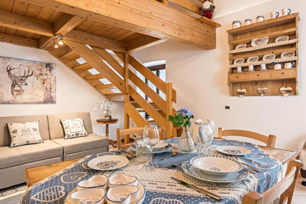 ein Esszimmer mit einem Tisch und einem Sofa in der Unterkunft Loft della Perpetua di Casa Bernardi, romantica mansarda nelle Dolomiti di Brenta in Montagnaga