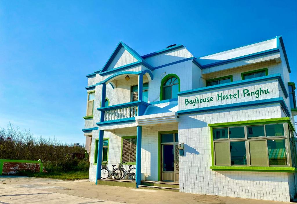 a blue and white building with bikes parked outside at 澎湖北吉光背包客民宿 Bayhouse Hostel Penghu in Magong