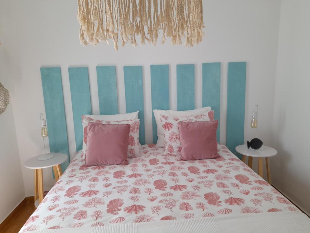 um quarto com uma cama com almofadas cor-de-rosa e rosa em Carlo's Beach Guest House em Odeceixe