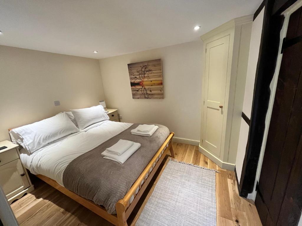 1 dormitorio con 1 cama con 2 toallas en Swan House Tea Room and Bed & Breakfast en Lydney