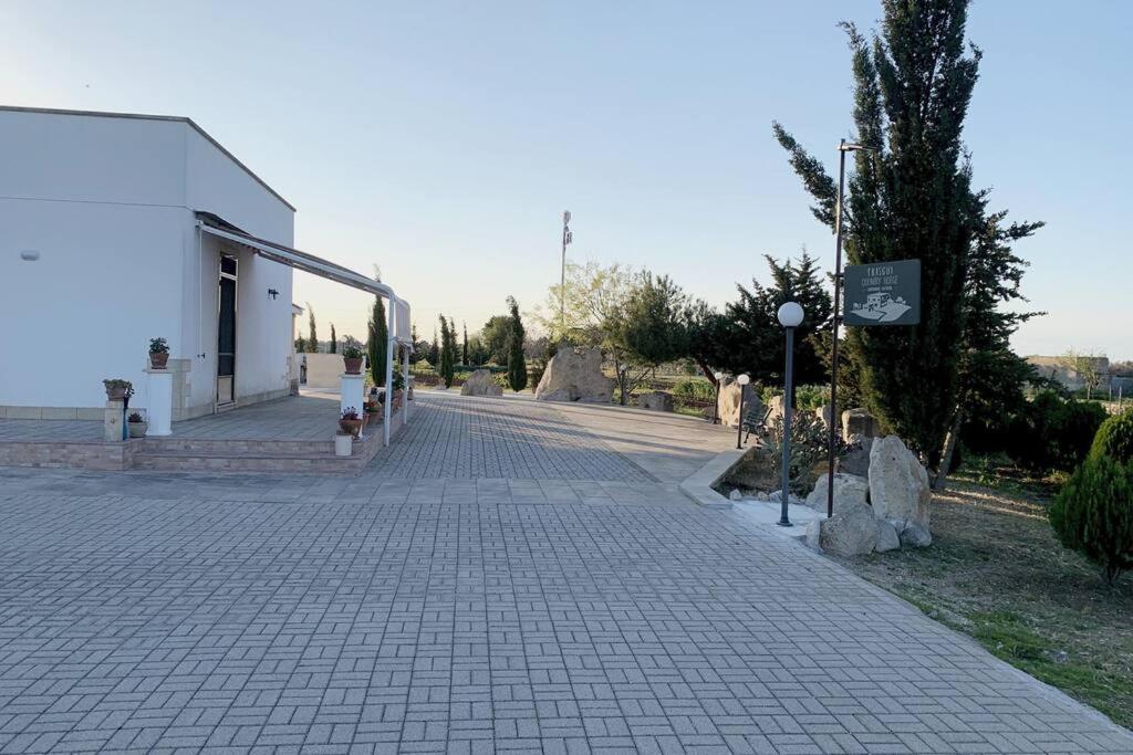 una calle adoquinada junto a un edificio blanco en Fraschi Countryhouse, en Carpignano Salentino