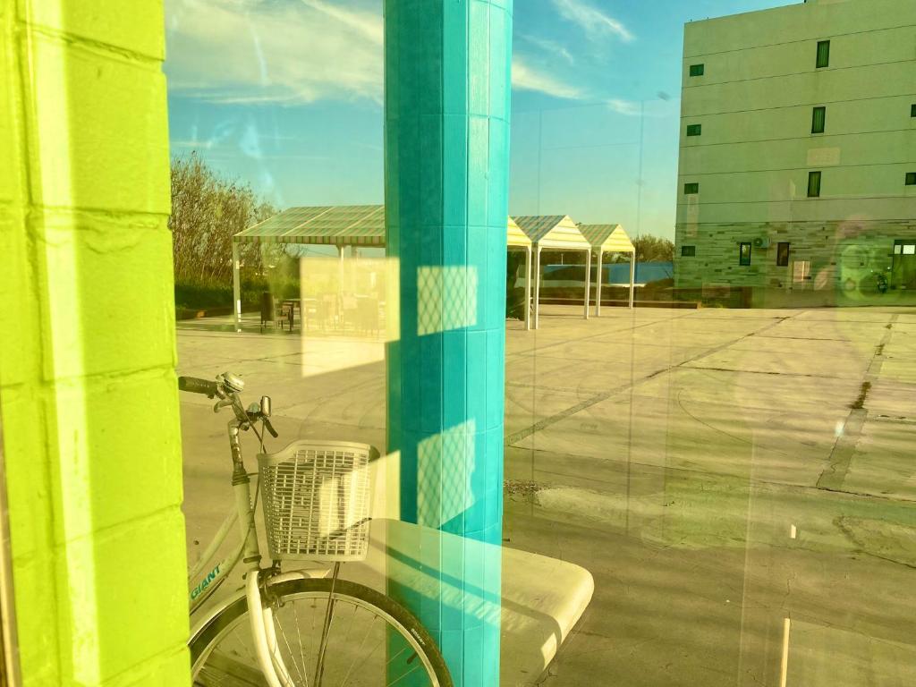 a bike leaning against a pole in a window at 澎湖北吉光背包客民宿 Bayhouse Hostel Penghu in Magong