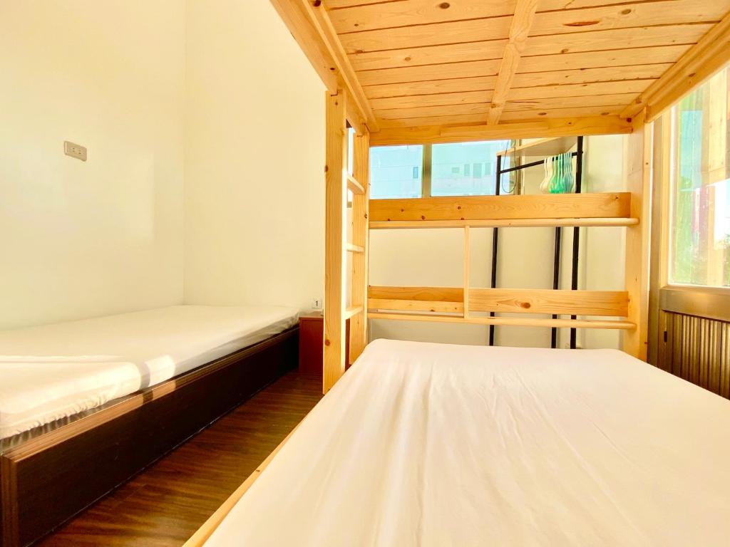 two bunk beds in a room with a window at 澎湖北吉光背包客民宿 Bayhouse Hostel Penghu in Magong