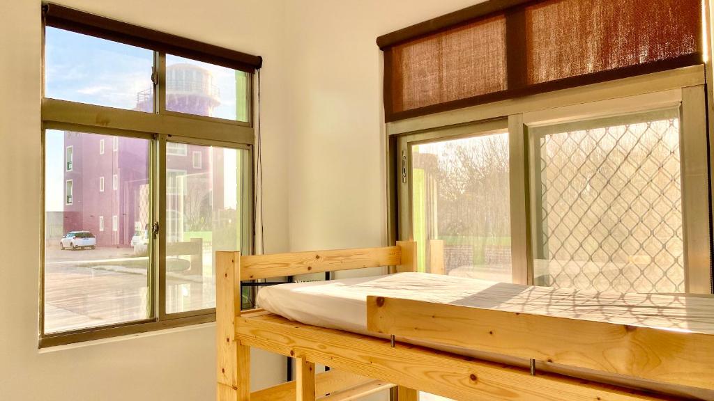 a wooden bunk bed in a room with a window at 澎湖北吉光背包客民宿 Bayhouse Hostel Penghu in Magong