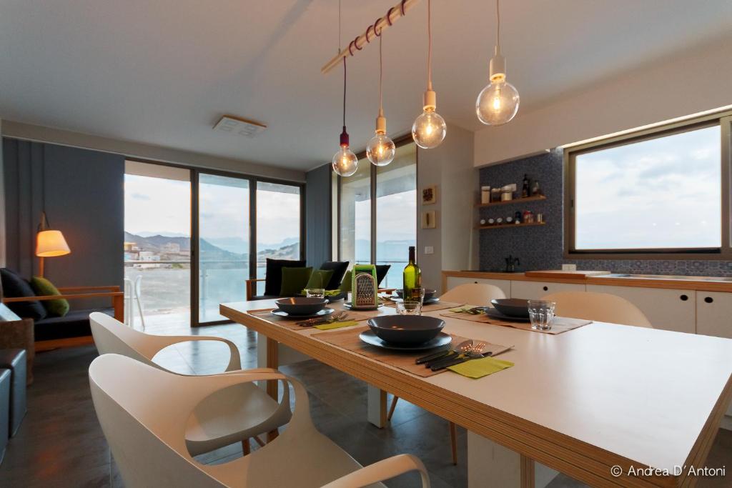 uma cozinha com mesa e cadeiras e uma sala de jantar em Seafront Holiday House on the Mindelo Bay em Mindelo