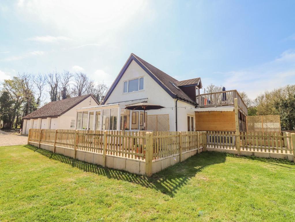 a house with a wooden fence in the yard at Deer View in Witney