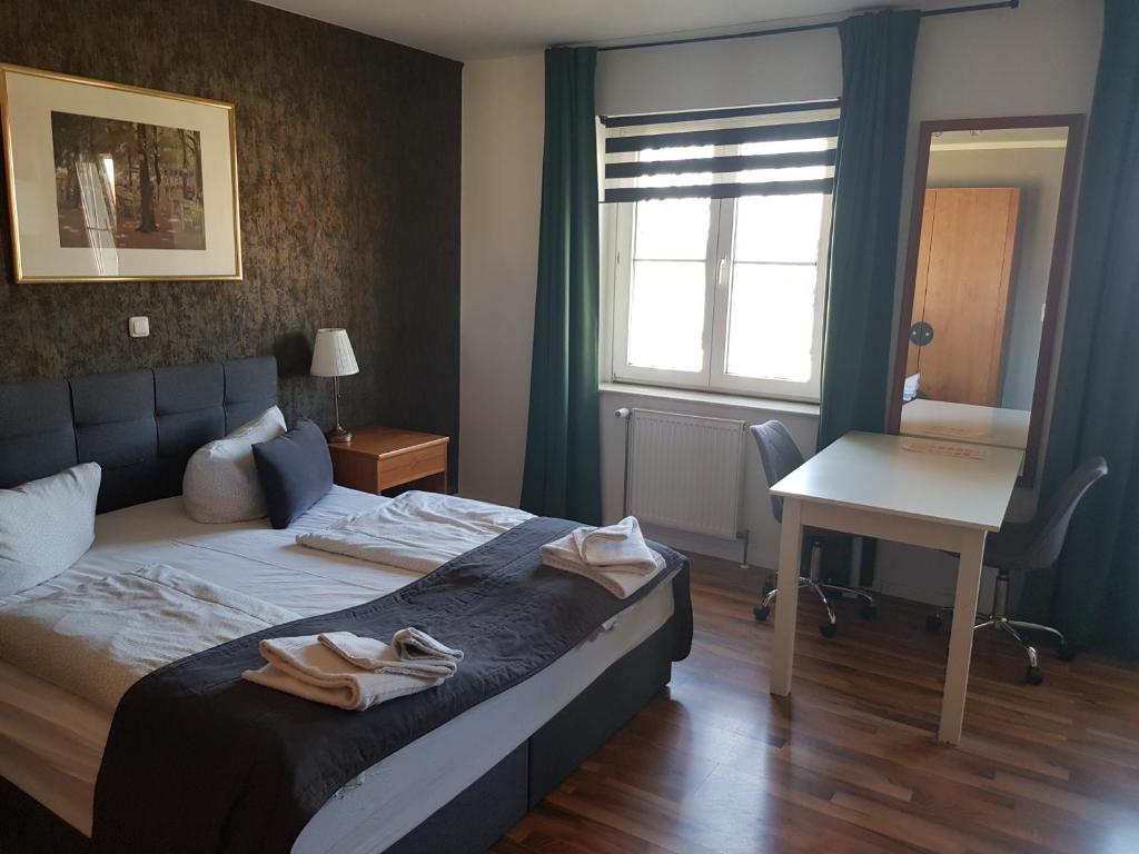 a bedroom with a bed and a desk and a window at Hotel Alt-Erfurt in Erfurt