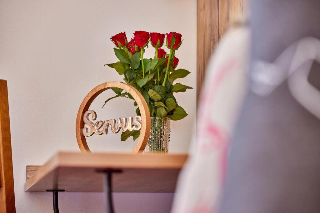 a vase of flowers on a shelf with a mirror at Gästehaus Angela in Garmisch-Partenkirchen