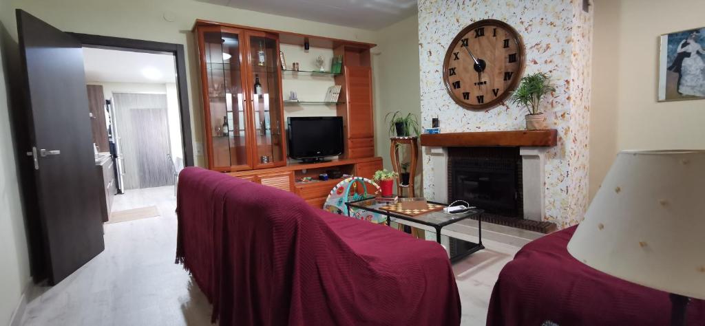 ein Wohnzimmer mit einem Sofa und einer Uhr an der Wand in der Unterkunft Cal Felico 
