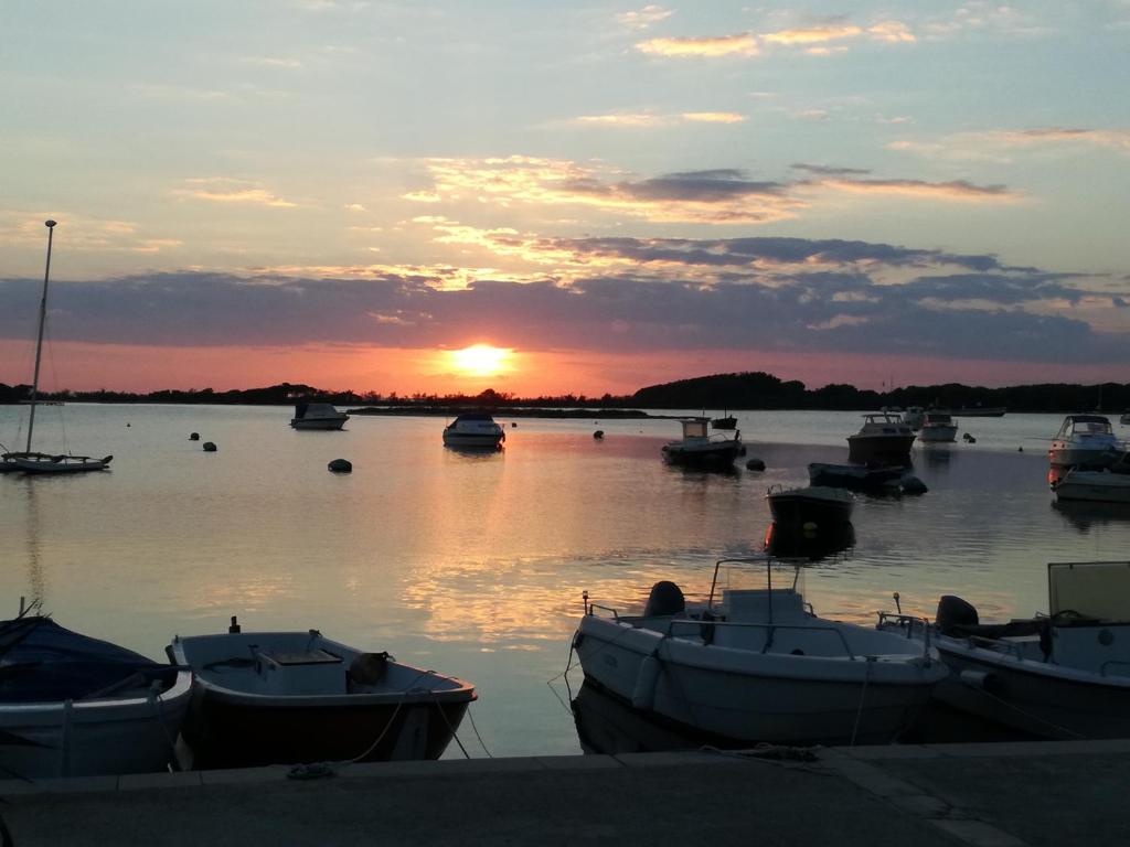 een groep boten in het water bij zonsondergang bij Villetta Summer in Porto Cesareo